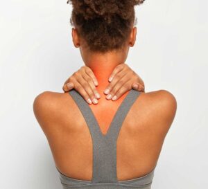 Woman holding her neck as she is struggling with neck pain
