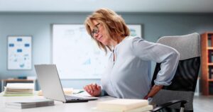 Woman suffering from back pain whilst sitting